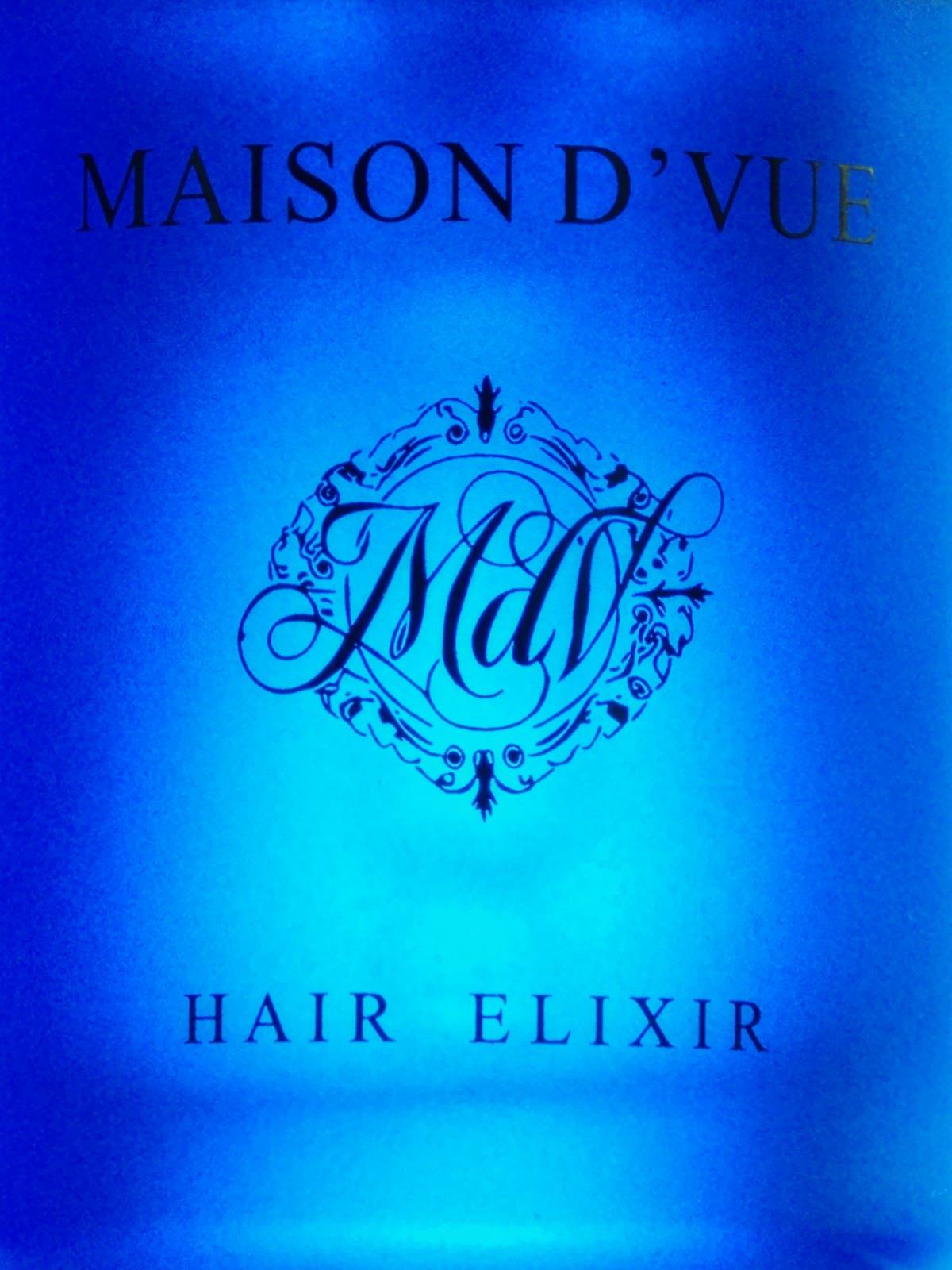 Macro of the MdV monogram on the elixir label, lit cobalt