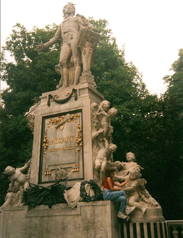 Masiela Lusha as a child at the Mozart Denkmal in Vienna's Burggarten, during the European years that shaped the founder of MAISON D'VUE